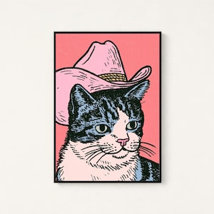 May include: A rectangular wall art print featuring a black and white tabby cat wearing a light pink cowboy hat. The cat has green eyes and a pink nose, set against a solid pink background. The illustration uses bold black outlines.