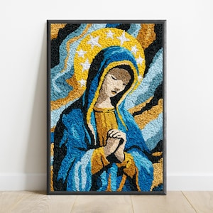 May include: A framed textile art piece featuring a textured, embroidered depiction of a figure with hands clasped in prayer. The figure wears a blue and gold head covering and robe, set against a background of swirling black, blue, and gold.
