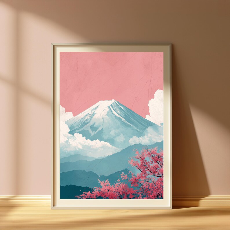May include: Framed art print featuring a serene mountain landscape. The artwork depicts a snow-capped mountain against a pink sky, with blue-toned mountains in the background and pink cherry blossoms in the foreground. The print is in a neutral-toned frame.
