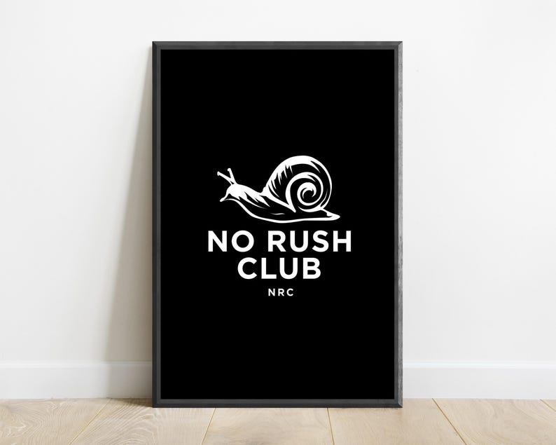 May include: A rectangular framed wall art piece featuring a black background with a white graphic illustration of a snail. Below the snail, the text reads NO RUSH CLUB in white capital letters, followed by the smaller white text NRC underneath.