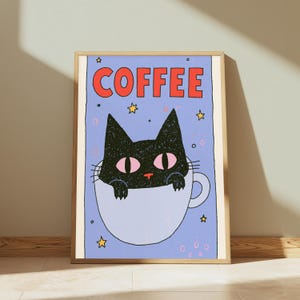 May include: A framed wall art print featuring a black cat with large pink eyes sitting inside a light blue coffee mug. The background is a light purple color with yellow stars and small circles. The word COFFEE is printed in large red letters.