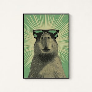 Peut inclure: Une impression d'art mural encadr&eacute;e repr&eacute;sentant un capybara portant des lunettes de soleil noires. L'animal est centr&eacute; sur un fond vert clair avec des lignes cr&egrave;me rayonnantes s'&eacute;tendant derri&egrave;re sa t&ecirc;te, cr&eacute;ant un effet de soleil.