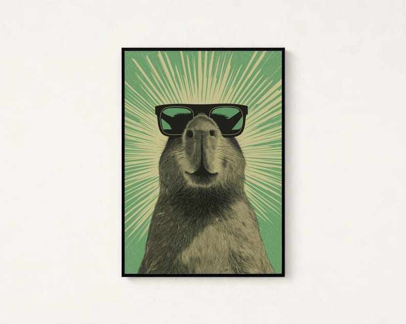 Peut inclure: Une impression d'art mural encadr&eacute;e repr&eacute;sentant un capybara portant des lunettes de soleil noires. L'animal est centr&eacute; sur un fond vert clair avec des lignes cr&egrave;me rayonnantes s'&eacute;tendant derri&egrave;re sa t&ecirc;te, cr&eacute;ant un effet de soleil.