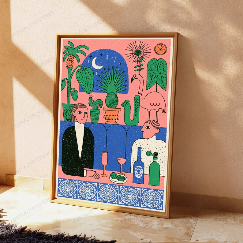 May include: A framed art print featuring a stylized illustration of two people sitting at a blue booth with a pink background. The scene includes a flamingo, potted plants, a crescent moon, a saxophone, two glasses, and two bottles on a table.