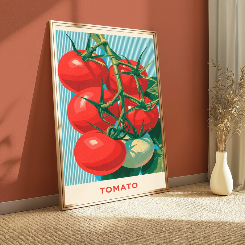 May include: A framed vertical wall art print featuring a cluster of bright red tomatoes on a green vine against a light blue background with vertical white stripes. The word TOMATO is printed in red capital letters at the bottom of the print.