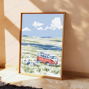 May include: A framed art print featuring a watercolor illustration of a red and white vintage camper van parked in a grassy field. A person sits in a folding chair next to the vehicle under a blue sky with white clouds and distant hills.