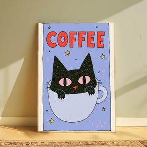 May include: A rectangular wall art print featuring a black cat with pink eyes peeking out of a light blue coffee cup. The word COFFEE is printed in large red letters at the top. The background is light blue with small yellow stars and pink circles.