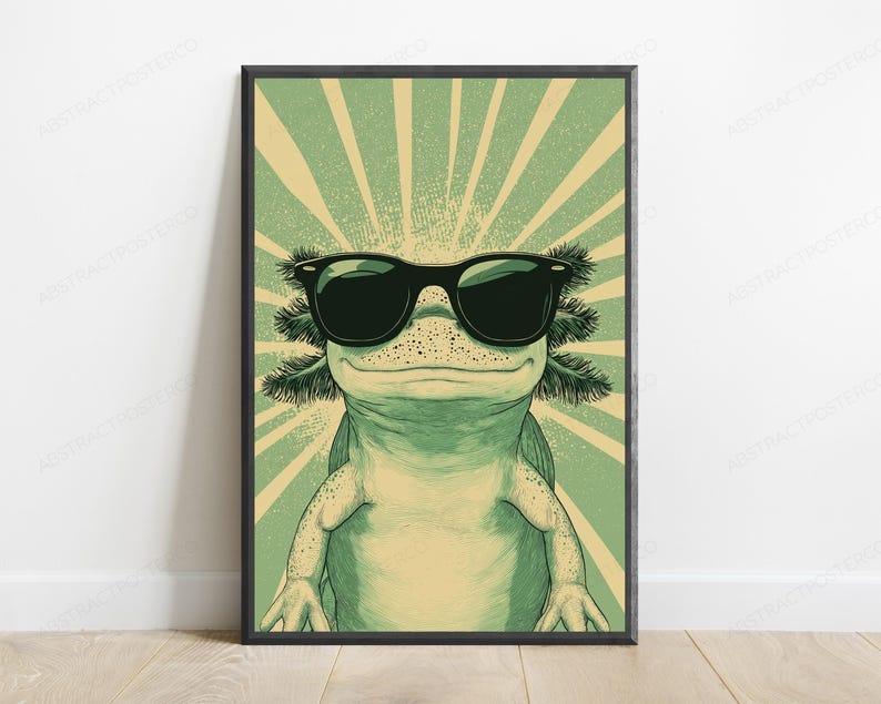 May include: A framed wall art print featuring a green axolotl wearing black sunglasses. The axolotl is centered against a background of radiating light green and cream-colored sunburst lines, creating a graphic illustration with a distinct color palette.