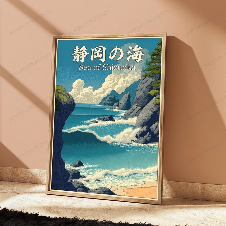 Puede incluir: Un p&oacute;ster vertical enmarcado que muestra un paisaje costero con acantilados rocosos, olas azules rompiendo y nubes blancas. El texto en la parte superior dice "静岡の海" en caracteres japoneses seguido del texto "Sea of Shizuoka".