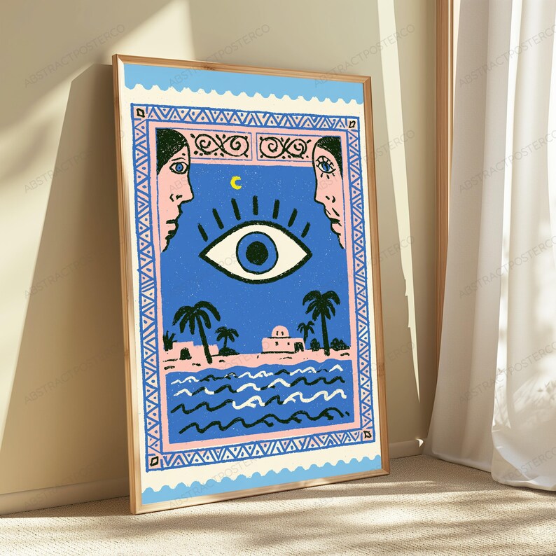 May include: A rectangular wall art print featuring a blue background with a central large eye, a yellow crescent moon, and two profile faces on the sides. The bottom section depicts a coastal scene with palm trees, buildings, and wavy water.