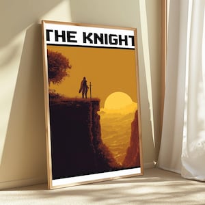 May include: A framed vertical poster featuring a pixel art illustration of a knight standing on a cliff edge at sunset. The text THE KNIGHT is printed in bold black block letters at the top. The scene displays a golden sun, a dark silhouette of a tree, and a deep canyon landscape in shades of orange and brown.