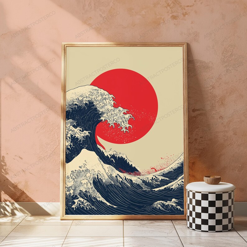 May include: A rectangular wall art print featuring a stylized dark blue ocean wave with white foam crests set against a cream background. A large, solid red circle is positioned behind the wave, creating a bold contrast in this graphic illustration.