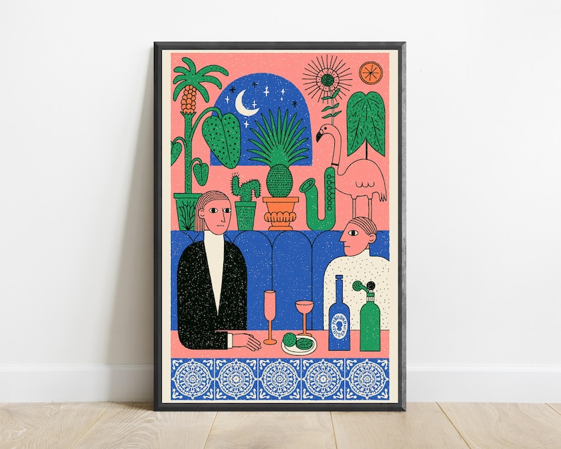 May include: A framed art print featuring a colorful illustration of two people sitting at a table. The scene includes potted plants, a flamingo, a saxophone, a crescent moon, and a blue tiled border. The figures are set against a pink background.