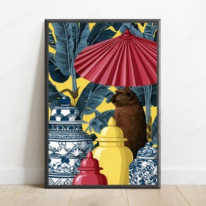 May include: A framed wall art print featuring a brown monkey standing under a large red parasol. The scene includes two blue and white patterned ginger jars, a solid yellow ginger jar, and a small red jar against a yellow background with dark blue tropical banana leaves.