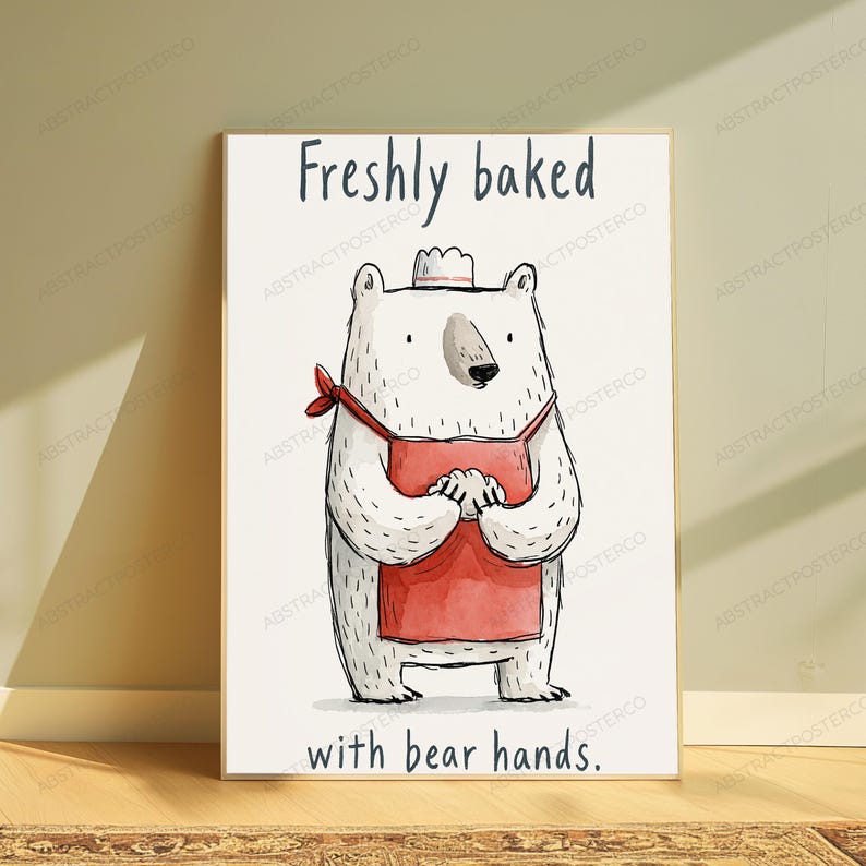 Puede incluir: Un p&oacute;ster blanco con un oso polar de dibujos animados que lleva un peque&ntilde;o gorro de chef y un delantal rojo. El oso est&aacute; de pie con las patas juntas. Sobre el oso aparece el texto "Freshly baked" y debajo "with bear hands."