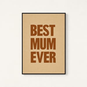 May include: A framed print with the words "BEST MUM EVER" in brown block letters on a tan background. The print is in a black frame and is centered on a white wall.