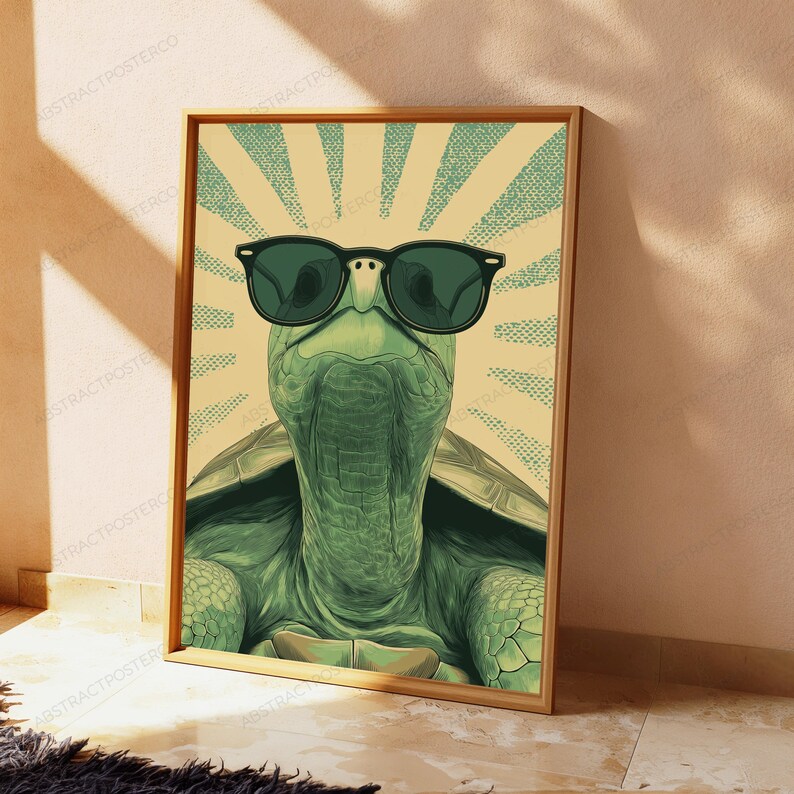 May include: A framed wall art print featuring a green turtle wearing black sunglasses. The turtle is centered against a light yellow background with a radiating sunburst pattern in teal dots. The artwork has a distinct graphic illustration style.