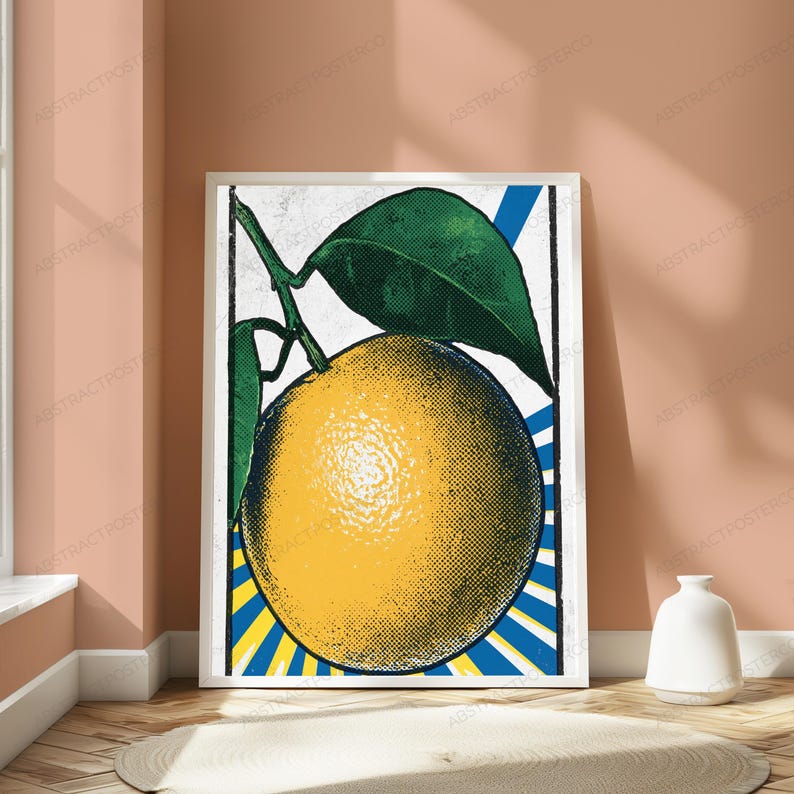 May include: A framed wall art print featuring a stylized yellow orange with a large green leaf. The background displays a vibrant blue and yellow sunburst pattern. The artwork utilizes a distinct halftone dot texture throughout the entire design.