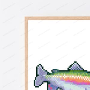 May include: A framed wall art print featuring a pixel art illustration of a fish. The fish is rendered in a vibrant gradient of colors including purple, green, orange, and white, set against a plain white background within a light wood frame.