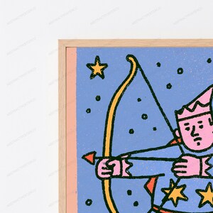 May include: A framed wall art print featuring a stylized illustration of a figure with pink skin wearing a pointed hat, holding a yellow bow and arrow against a blue background with scattered yellow stars and black outlines in a light wood frame.
