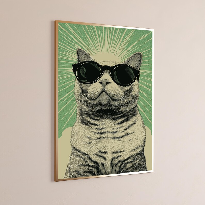 Puede incluir: Una l&aacute;mina de arte mural enmarcada con una ilustraci&oacute;n detallada de un gato atigrado con gafas de sol negras. El gato est&aacute; centrado sobre un fondo verde con l&iacute;neas blancas radiantes, todo ello dentro de un fino marco de color dorado.