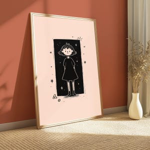 May include: A framed wall art print featuring a pale pink background with a central black rectangular panel. Inside the panel is a line-art illustration of a figure with short hair wearing a simple dress, surrounded by small star and circle motifs.