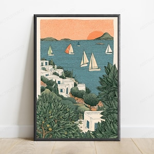 May include: A framed art print featuring a coastal scene with white buildings nestled among green trees and bushes. The blue sea contains several sailboats with white and orange sails under a soft orange sunset sky with distant hills.