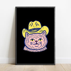 Puede incluir: Una impresi&oacute;n de arte mural enmarcada que presenta una ilustraci&oacute;n gr&aacute;fica de un gato rosa con un sombrero de vaquero amarillo. El gato tiene ojos amarillos y una peque&ntilde;a nariz roja, delineado con trazos negros gruesos sobre un fondo negro.