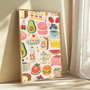 May include: A rectangular wall art print featuring a light pink background with a repeating pattern of food items including strawberries, avocado halves, pink macarons, slices of cake, a teapot, a pink toaster, a burger, and a carton of strawberry milk.