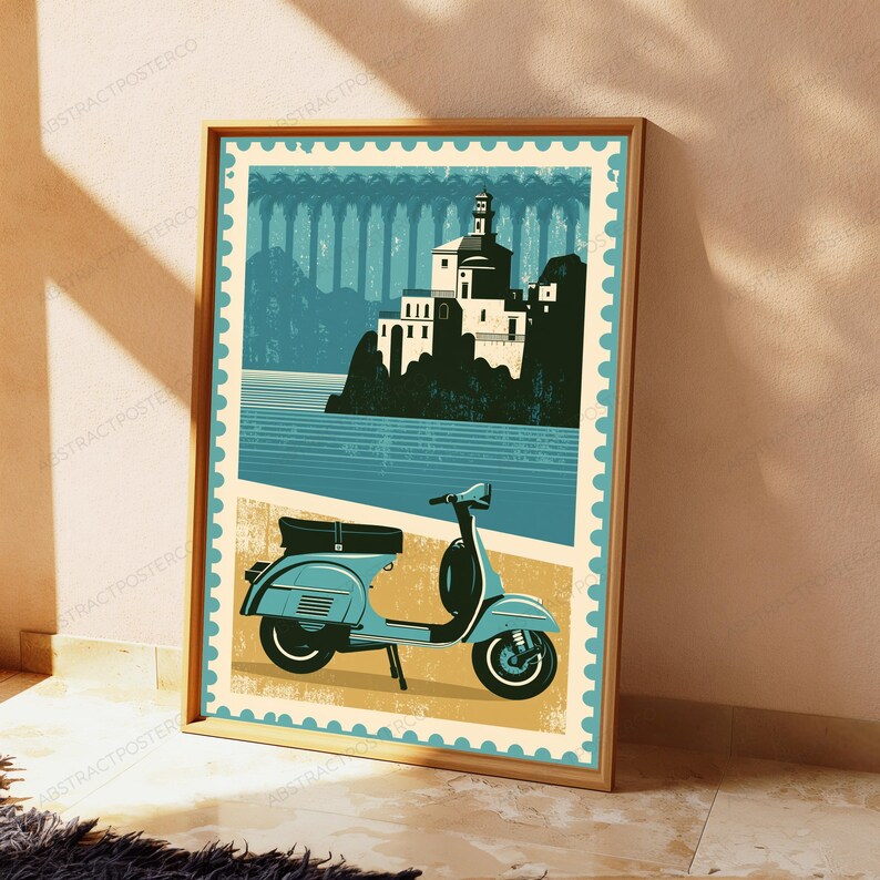 May include: A rectangular wall art print designed like a postage stamp featuring a light blue motor scooter in the foreground. The background displays a stylized illustration of a white building on a cliff overlooking a body of water in shades of blue.
