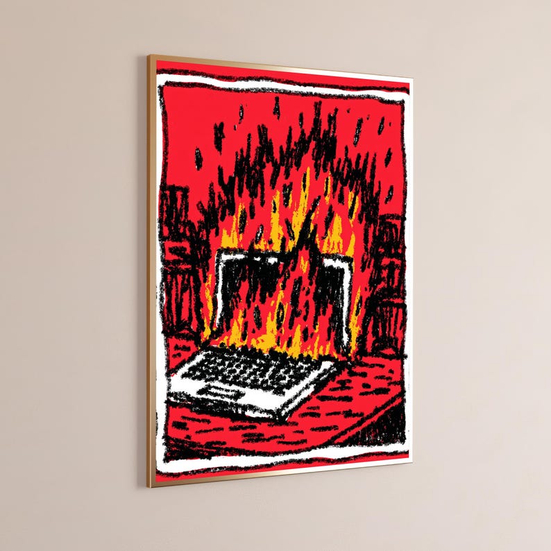 May include: A framed wall art print featuring a stylized, hand-drawn illustration of a laptop engulfed in bright yellow and orange flames against a vibrant red background. The artwork uses bold black outlines and a textured, crayon-like aesthetic.