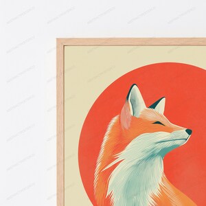 May include: A framed wall art print featuring a stylised fox illustration. The fox is rendered in shades of orange and white with fine line details, positioned against a large, solid red circular background on a light beige rectangular field.