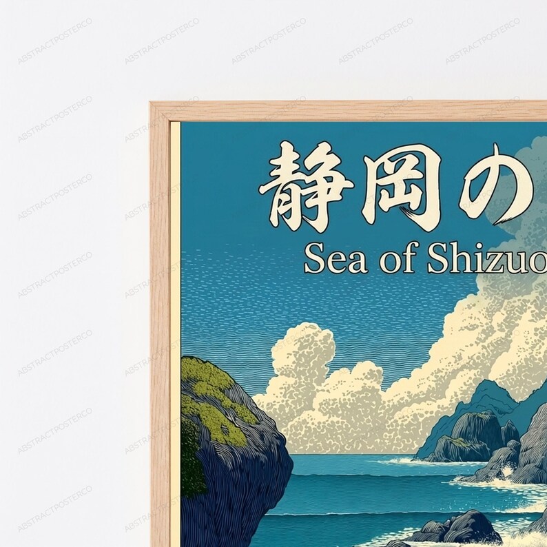 Puede incluir: Una l&aacute;mina art&iacute;stica enmarcada que muestra un paisaje costero estilizado con acantilados rocosos oscuros, un mar azul profundo y grandes nubes blancas sobre un cielo azul. El texto "静岡の" y "Sea of Shizuoka" aparece impreso en blanco arriba.