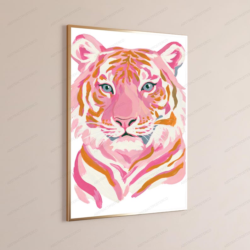 May include: A rectangular wall art print in a thin gold frame featuring a stylized tiger head illustration. The tiger is rendered in shades of light pink, magenta, and orange with white highlights and piercing blue eyes against a white background.