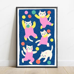 May include: A framed art print featuring five white cats wearing pink overalls against a textured dark blue background. The cats are depicted in various playful poses, surrounded by scattered colorful circles in shades of yellow, orange, pink, and green.