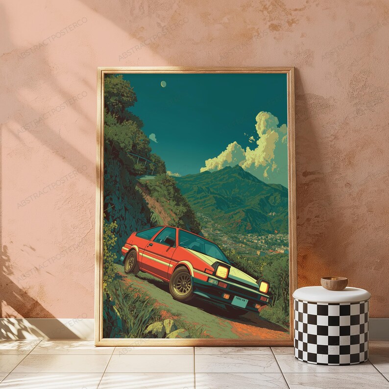 May include: A framed art print featuring a red and yellow sports car driving on a winding mountain road. The scene includes lush green hills, a distant town, and a blue sky with white clouds. The artwork has a retro, illustrated aesthetic style.