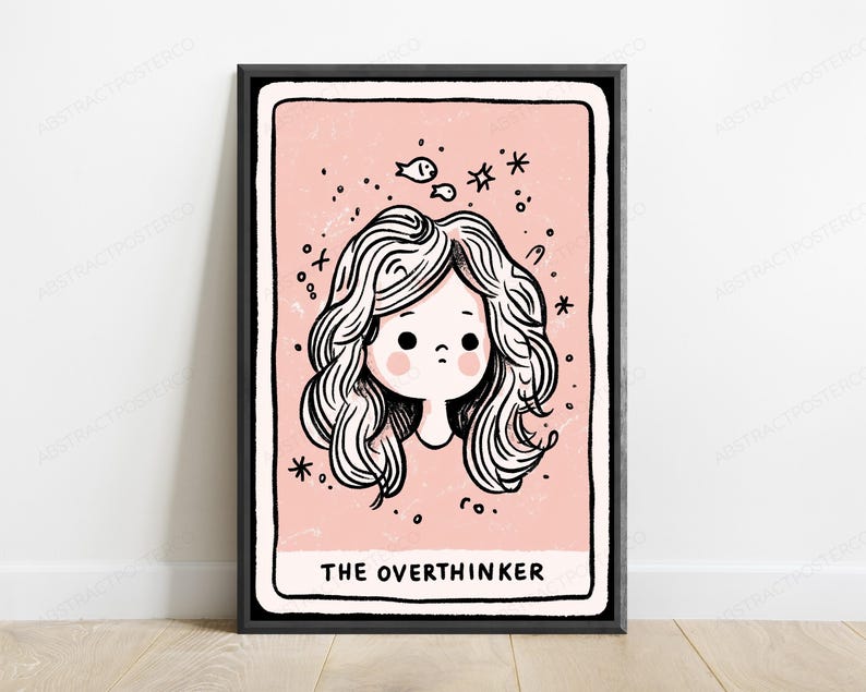 May include: A framed wall art print featuring a pale pink background with a black and white line drawing of a person with wavy hair. The illustration includes small fish and star icons, with the text THE OVERTHINKER printed at the bottom.