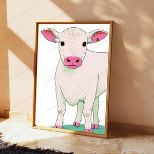 Peut inclure: Une impression d'art encadr&eacute;e repr&eacute;sentant une illustration stylis&eacute;e d'un veau blanc avec des oreilles, un museau et des sabots roses. Le veau se tient sur une parcelle d'herbe verte sur fond blanc, le tout dans un cadre en bois clair.