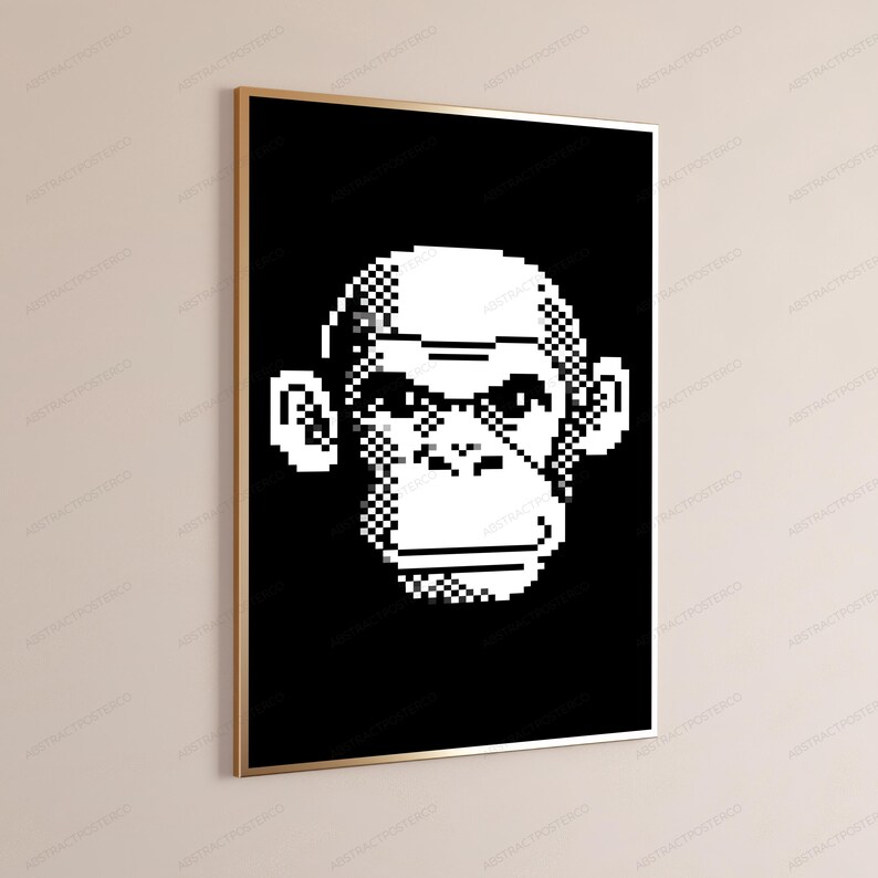 May include: A rectangular wall art print featuring a pixelated white monkey face centered on a solid black background. The artwork is encased in a thin, metallic gold frame, presenting a high-contrast graphic design with sharp, blocky edges.
