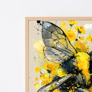 May include: A framed watercolor painting featuring a close-up of a bumblebee with black and yellow fuzzy textures and translucent grey wings. The bee is surrounded by vibrant yellow floral splashes and splatters on a light beige background.
