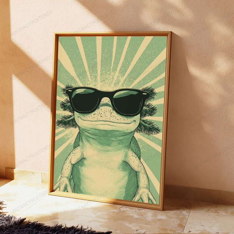 May include: A rectangular wall art print featuring a light green axolotl wearing large black sunglasses. The background consists of a radiating sunburst pattern in alternating shades of light green and cream, creating a retro graphic illustration.