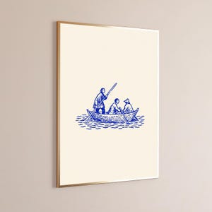 Puede incluir: Una l&aacute;mina de arte mural enmarcada con una ilustraci&oacute;n en tinta azul de tres figuras en un peque&ntilde;o bote de remos sobre el agua. Las figuras est&aacute;n representadas con trazos, una de pie remando y dos sentadas. El fondo es de color crema.