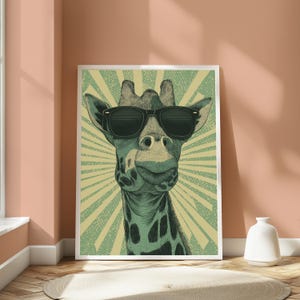 May include: A framed wall art print featuring a stylized illustration of a giraffe wearing black sunglasses. The giraffe is depicted in shades of green and black against a light yellow background with a radiating sunburst pattern behind the head.