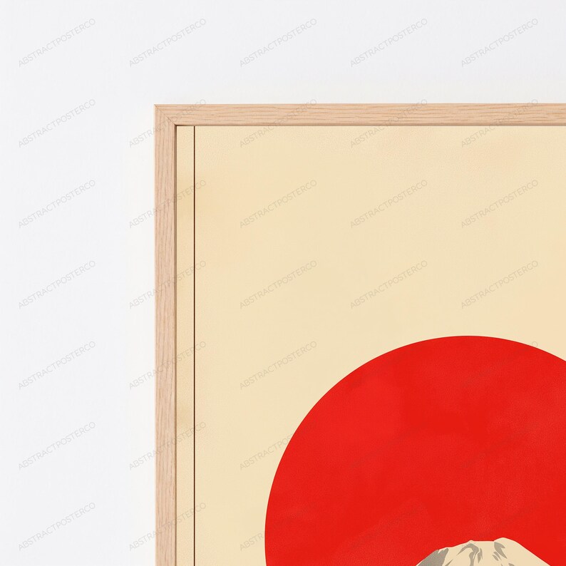 May include: A framed wall art print featuring a large, solid red circle set against a light cream background. The bottom portion of the print displays a stylized mountain peak in shades of gray and white, all encased in a light wood frame.