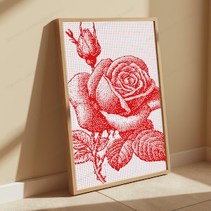 Pode incluir: Uma pe&ccedil;a de arte de parede retangular emoldurada com uma ilustra&ccedil;&atilde;o pontilhada em vermelho de uma rosa em flor e um bot&atilde;o de rosa sobre um fundo branco. A obra utiliza um estilo de matriz de pontos para criar sombreamento e textura, em uma moldura de madeira clara.