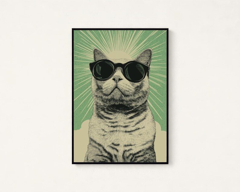 Puede incluir: Una l&aacute;mina de arte enmarcada con una ilustraci&oacute;n detallada de un gato atigrado que lleva puestas unas gafas de sol negras grandes. El gato est&aacute; centrado sobre un fondo verde con rayos de sol blancos y una base de color beige claro abajo.