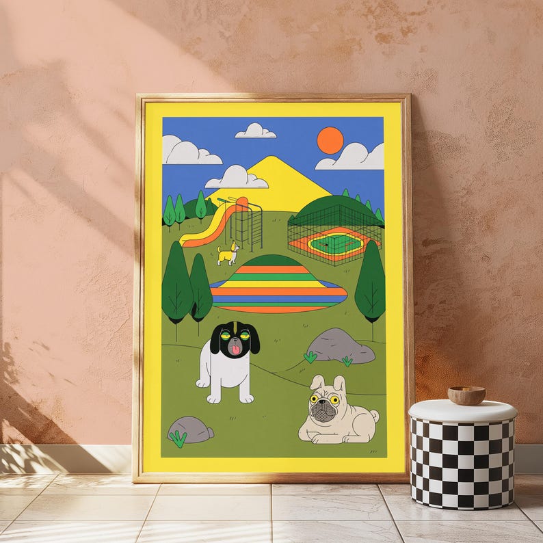 May include: A framed art print featuring a colorful park scene with a yellow slide, a fenced area, and a striped hill. Two dogs are in the foreground: a black and white dog with a yellow stripe on its head and a tan pug-like dog lying on the grass.