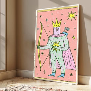 K&ouml;nnte beinhalten: Ein gerahmter Wandkunstdruck mit einer stilisierten Figur, die eine gelbe Krone und einen rosa Umhang tr&auml;gt und einen gelben Bogen mit Pfeil h&auml;lt. Die Figur ist hellgr&uuml;n mit einem gelben Stern auf der Brust vor einem texturierten rosa Hintergrund.