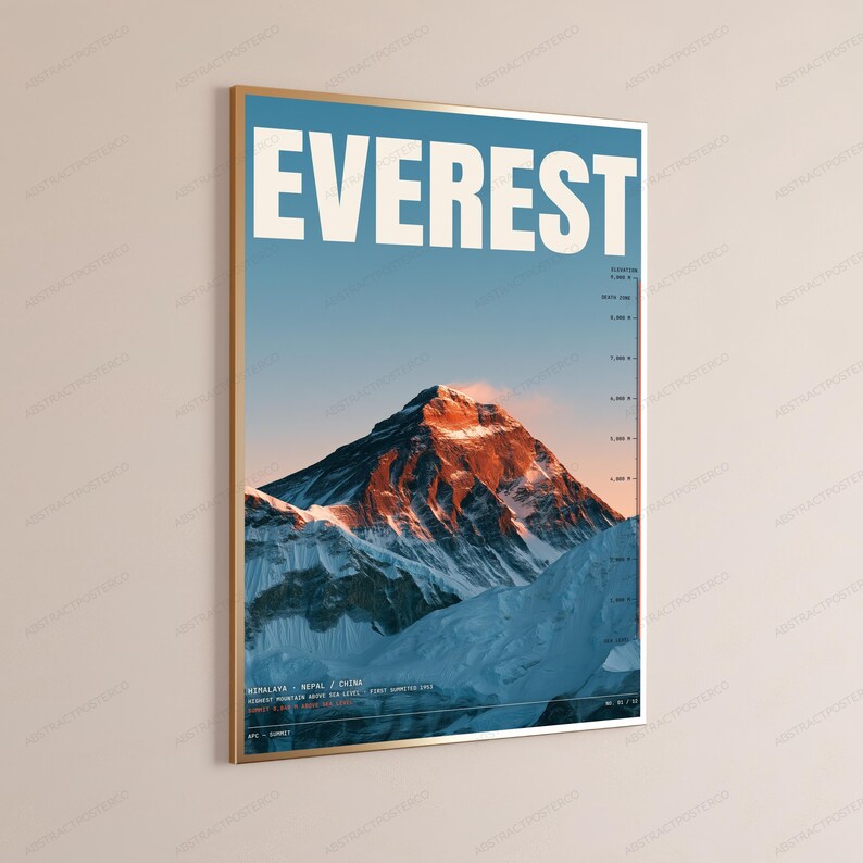 Op de afbeelding: Een ingelijste wandposter met een grafische illustratie van de Mount Everest. Het woord EVEREST staat bovenaan in grote witte hoofdletters gedrukt. De afbeelding toont een besneeuwde bergtop met oranje zonlicht tegen een blauwe lucht.
