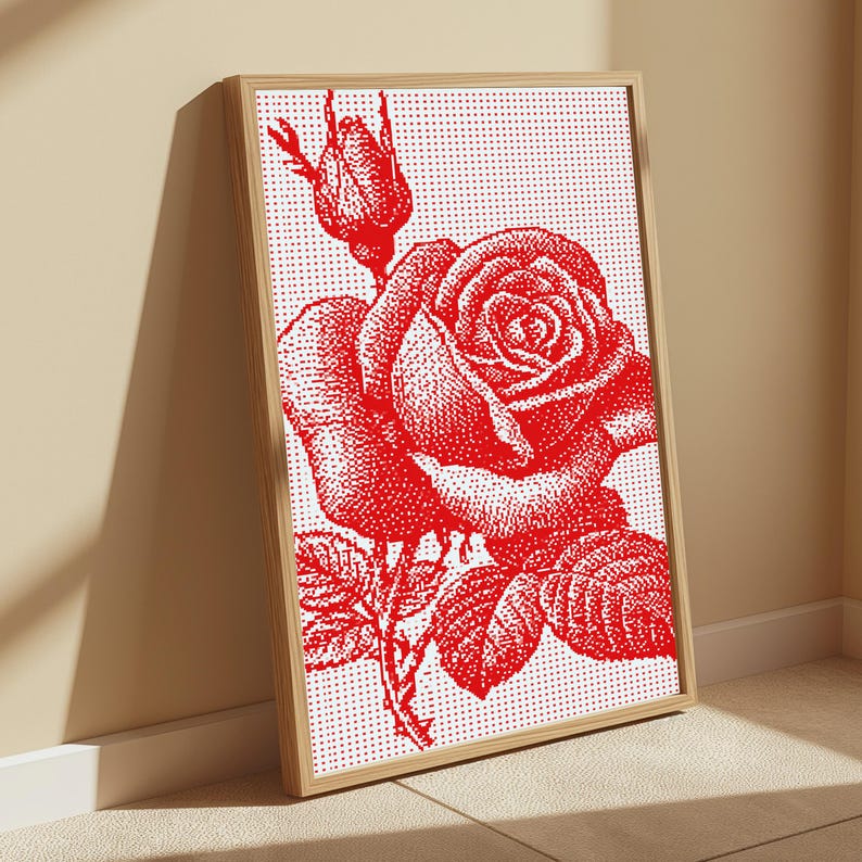 Pode incluir: Uma pe&ccedil;a de arte de parede retangular emoldurada com uma ilustra&ccedil;&atilde;o de uma rosa vermelha sobre um fundo branco. O design utiliza um padr&atilde;o de pontos para representar uma rosa em flor e um bot&atilde;o com folhas e espinhos numa moldura de madeira clara.